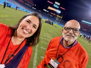 Leigh Ann Hubbard and Steve Moran pose on the Tennessee Titans football field at Nissan Stadium.